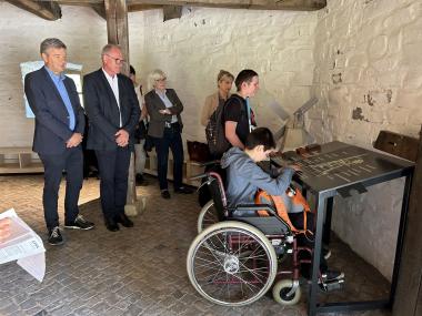 Christian Lange (v.l./Förderkreis), Wolfram Schulte (Firma Bandstahl-Schulte), stellvertretende Museumsleiterin Dr. Anke Hufschmidt, die wissenschaftliche Mitarbeiterin Fenja Reuter sowie die Museumsbesuchenden Marcel und Enea (LWL-Berufsbildungswerks Soest) bei der Eröffnung der Taststation in der historischen Windmühle.<br>Foto: LWL/Marie Hangebrauck