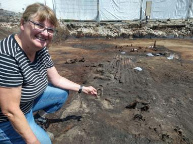 Grabungsleiterin Marianne Moser freut sich über die ersten Funde und die gut erhaltenen mittelalterlichen Hölzer.<br>Foto: LWL-Archäologie für Westfalen/S. Spiong