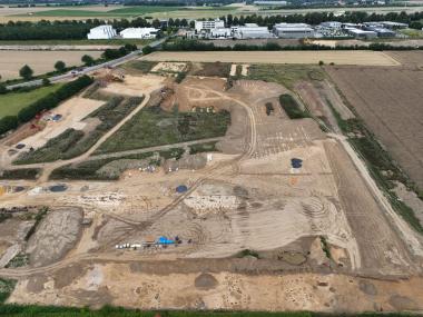 Luftbild der Grabungsfläche, Blick nach Norden. Oben ist die B1 und der Flughafen Dortmund zu erkennen. Unten im Bild sind die Pfostengrundrisse der jungsteinzeitlichen Häuser zu erkennen.<br>Foto: LQ Archäologie/C. Bariszlovich