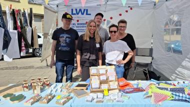 Am Stand der LWL-Tagesstätte Brackel gibt es Infos und Selbstgemachtes. Die Gäste begrüßen (v.l.n.r.) Karsten Wibbelt (Nutzer), Sabrina Herting (Stellv. Teamleitung Tagesstruktur), Christian Wulfert (Heilerziehungspfleger), Tanja-Katharina Krüger (Ökotrophologin) und Bianka Ziesmer (Nutzerin).<br>Foto: LWL / Philipp Stenger
