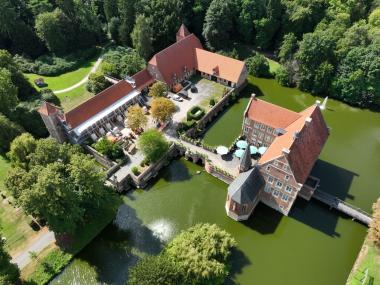 Blick von Osten auf Burg Hülshoff. Auf der linken Bildseite weisen Gerüste und Abstützungen auf die aktuellen Arbeiten auf der Vorburg hin. Die archäologischen Untersuchungen fokussieren sich derzeit dort auf Bodeneingriffe im Gebäudeinneren.<br>Foto: LWL/Rudolf Klostermann