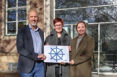 Mit sicherer Hand durch die Jugendhilfe: Thomas Fink, LWL-Jugend- und Schuldezernentin Birgit Westers und Henrike Steff mit dem Steuerrad als Symbol für verlässliche Orientierung für Jugendhilfeausschüsse.<br>Foto: Gleis/LWL