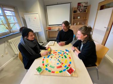 (v.l.): Sarah Schirra, Martin Schirra und Anika Weil im LWL-Wohnverbund Dortmund mit dem Biografiespiel "Die Schatzsuche".<br>Bild: LWL/Michaela Rensing