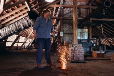 Vorführerin Silke Schäfer zeigt, wie der Ringofen über die Ofendecke befeuert wird, sodass die Ziegel bei konstanten 1.000 Grad optimal gebrannt werden.<br>Foto: LWL/ Tom Stöven