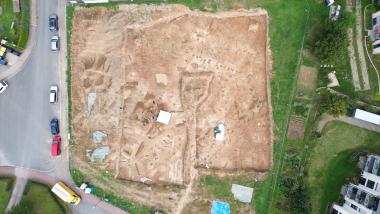 Drohnenaufnahme der Grabungsfläche mit den ausgegrabenen archäologischen Befunden. Die Siedlung setzt sich nach bisherigen Erkenntnissen außerhalb des Baufeldes weiter fort. Foto: Archäologie am Hellweg e.G./Angelina Friedrich