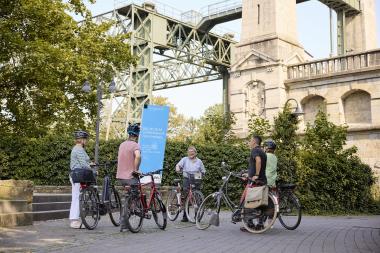 Herbert Niewerth mit einer Radlergruppe am Schiffshebewerk Henrichenburg.<br>Foto: LWL / Julia Gehrmann