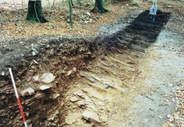 Im Suchschnitt fanden die Archäologen Reste der mindestens 2000 Jahre alten Befestigungsanlagen auf der Bergkuppe (im Bild links vorne).    Foto: B. Schneider