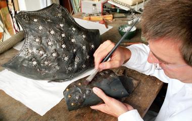 Einen Brustharnisch und Beinzug aus der Rüstkammer von Haus Herbede konserviert LWL-Restaurator Andreas Weisgerber für die Ausstellung im neuen Westfälischen Museum für Archäologie in Herne. <br>Foto: LWL</br>