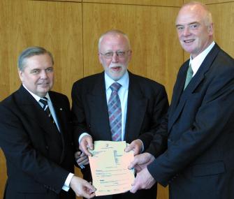 Landtagspräsident Ulrich Schmidt (v. l.) und Regierungspräsident Wolfram Kuschke überreichen den Zuwen-dungsbescheid an LWL-Direktor Wolfgang Schäfer. <br>Foto: Landtag NRW/Schälte</br>