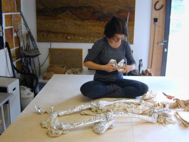 Restauratorin Heike Krainitzki bereitet für das neue Archäologie-Museum in Herne die originalgetreue Rekonstruktion eines Grabes aus der Zeit der frühen Bauern in Westfalen vor 5.000 Jahren vor. Die Restauratorin wickelt die Knochen in Alufolie, um den Fund bei der Arbeit vor dem Kunststoff zu schützen, in dem das Skelett eingebettelt wird.<br>Foto: LWL/Hagen Schulz-Hanke</br>