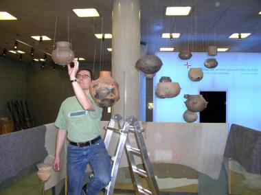 Vorsichtig installiert Restaurator Sebastian Pechtold im neuen LWL-Archäologie-Museum eine Auswahl der frühesten Keramik in Westfalen - darunter auch 6.500 Jahre alte Gefäßscherben aus Bochum. <br>Foto: LWL/Spiong</br>