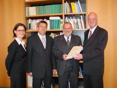 Prof. Martin Burgi (2.v.l.) und seine Mitarbeiterin Bettina Ruhland übergeben die Dokumentation an die beiden Direktoren Udo Molsberger (2.v.r.) und Wolfgang Schäfer (r.)<br>Foto: LWL</br>