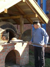 Uwe Wiese nimmt den neuen Lehmbackofen in Betrieb. <br>Foto: LWL</br>