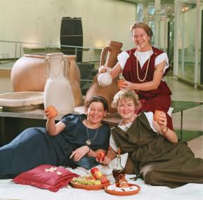 Dr. Carola Kintrup (sitzend), Alessandra Shmelzer (links) und Gaby Olthoff (rechts) informieren im LWL-Römermuseum über diedie "tollen Tage" im alten Rom und laden die Besucher ein, Kerzen mit römischen Mustern zu gestalten.<br>Foto: LWL/Sagurna</>br