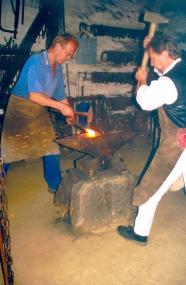 Auch bei der größten Hitze formen die beiden Schmiede Wolfgang Göhmann (re.)und Benedikt Zellerhoff (li.) im Detmolder LWL-Museum das heiße Eisen ¿ zur Not schmieden sie auch Ersatzteile für defekte Kinderwagen<br>Foto: LWL</br>