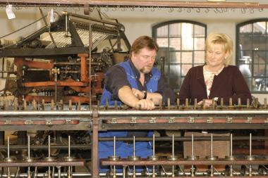 Felix Brumann und Sigrid Hungerkamp an der Zwirnmaschine, im Hintergrund ist die Spinnkrempel zu sehen.<br>Foto: LWL/Holtappels</br>