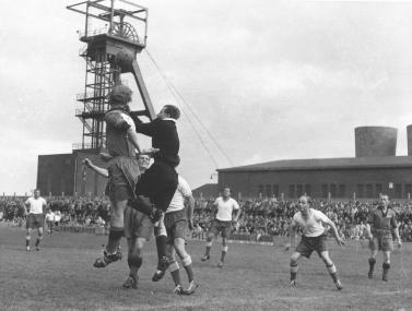 Revierfußball im Schatten der Fördertürme. Spiel des SV Sodingen auf seiner Glück-Auf-Kampfbahn an der Zeche Mont-Cenis, Anfang 1950er Jahre. <br>Foto: Ausstellung "Fußballregion Ruhrgebiet"</br>