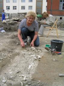 Teresa Kaczmarczyk, Mitarbeiterin des Grabungsteams, legt die ersten Knochen eines Grabes frei.<br>Foto: LWL/Spiong.</br>