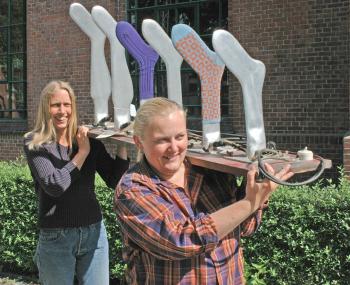 Füße hoch! Die Museumsmitarbeiterinnen Anne Bodenbinder (l.) und Renate Uphoff schultern einen Strumpfformer, der in den 1960er Jahren in der Strickerei Rüger in Sprockhövel (Ennepe-Ruhr-Kreis),zuvor in Kaufungen in Sachsen, eingesetzt war. <br>Foto: LWL/Holtappels<br />