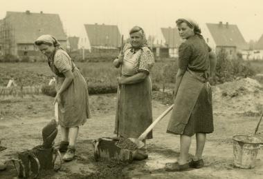 Frauenarbeit: Ziegelsteine waren 1948/49 auf dem Markt schwer zu bekommen. Steine wurden daher in Eigenarbeit hergestellt. Die Frauen mischten Hochofenschlacke, Sand und Zement mit Wasser an und stampften die Masse in eine Eisenform. Links im Bild Helene Kamolz. <br/>Foto: privat