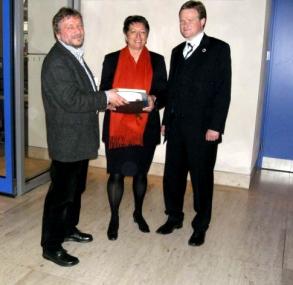 LWL-Museumsleiter Herbert Niewerth (l.) und Bundestagsabgeorneter Frank Schwabe (r.) übergeben die 8000 Unter-schriften an die Parlamentarische Staatssekretärin Karin Roth.