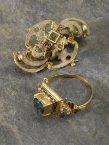 Goldener Fingerring und Gewandspange aus dem Abortschacht eines Adelshofes in Höxter. Foto: LWL/S. Brentführer.