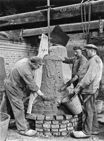 Arbeiter beim Bestreichen des Kerns mit Lehm. <br>Foto: Gießerei Petit & Gebr. Edelbrock, Gescher<br />