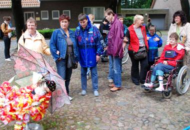Die Gruppe von Menschen mit Behinderungen bestaunt Isa Genzskens farbenfrohe Installation.		Foto: LWL/Hintzler