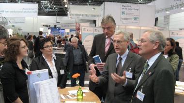 LWL-Direktor Dr. Wolfgang Kirsch (v. r.), Ulrich Adlhoch, Leiter des LWL-Integrationsamtes Westfalen, und LWL-Sozialdezernent Matthias Münning erklären Besucher der Messe Reha-Care wie der LWL Arbeitgeber dabei unterstützt, Arbeitsplätze für Menschen mit Behinderung zu schaffen. Foto: LWL