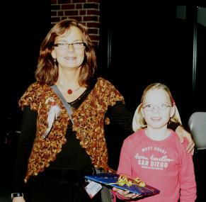 Museumspädagogin Cornelia Ramthun freut sich, dass Sophie aus Senden als begeisterter Dino- und Indianerfan ihren achten Geburtstag im LWL-Museum für Naturkunde feiert. Foto: LWL/Thomas