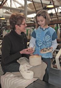 Die Initiatorin der Ausstellung ¿Monogramme, Spitzen und Bänder¿, Antonia Euting, zeigt Kindern wie aus alten Erbstücken neue textile Kreationen entstehen. <br>Foto: LWL<br />