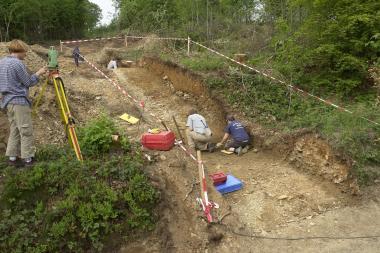 Profilschnitt durch zwei Hohlwege der Eisenstraße, in denen die Ausgräber (vorne rechts und hinten) knieen und die Fahrrinnen freilegen.<br>Foto: LWL/Menne<br />