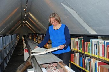 Altes Förderband in neuem Wissensspeicher: Bibliothekarin Marie-Rose Vorgrimler hat den Bücherbestand bereits einsortiert.<br>Foto: LWL<br />