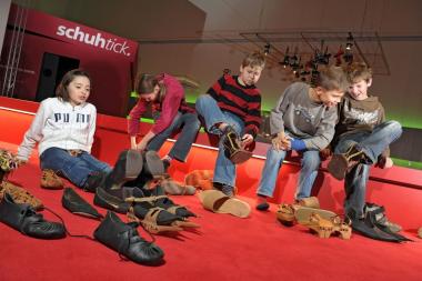 Kinder probieren in dem Programm "Komm' in die Puschen" Schuhe aus verschiedenen Zeiten und Orten an.<br>Foto: Stefan Kuhn. <br />