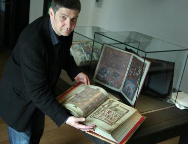 Kurator Dr. Matthias Preißler gibt der verlängerten Faksimile-Ausstellung im LWL-Landesmuseum für Klosterkultur ein neues Gesicht. Hier blättert er die Kopie des Buchs von Lindisfarne (8. Jahrhundert) um.<br>Foto: LWL/Tillmann<br />