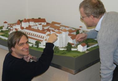 Museumsleiter Dr. Martin Kroker (links) und Kurator Dr. Clemens Kosch sind stolz auf das Modell der mittelalterlichen Benediktinerabtei Cluny, das eigens für die Dauerausstellung im LWL-Landesmuseum für Klosterkultur angefertigt wurde. <br>Foto: LWL/Maria Tillmann<br />