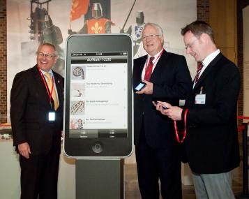 LWL-Direktor Dr. Wolfgang Kirsch, der Präsident des Sparkassenverbandes Westfalen-Lippe, Dr. Rolf Gerlach, und Museumsleiter Dr. Josef Mühlenbrock präsentierten die elektronischen Multimediaführer. Die 34 Stopps des Gerätes könne auch direkt über die Exponatbilder angesteuert werden.<br>Foto: LWL/Brentführer<br />