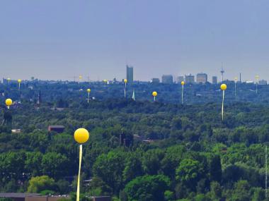 Große gelbe Ballons schweben ab Samstag (22.5.) über den ehemaligen Schachtanlagen des Reviers. Diese Fotomontage zeigt ein Panorama vom Tippelsberg, Bochum. <br>Foto: SchachtZeichen/ujesko/Moos<br />