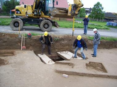 Mit Hilfe der Kranfunktion eines Baggers werden die schweren Betonplatten von dem Schacht entfernt. <br>Foto:LWL/Best.<br />