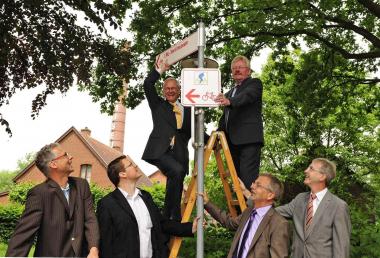 LWL-Direktor Dr. Wolfgang Kirsch (l.) und Bocholts Bürgermeister Peter Nebelo (r.) haben eines der letzten Radwegschilder am LWL-Textilmuseum angebracht. Mit dabei waren LWL-Museumsleiter Hermann Stenkamp (vorne v.l.), Fabian Fohlmeister und Wilhelm Angenendt vom Planungsbüro AB Stadtverkehr und Stadtbaurat Ulrich Paßlik . <br>Foto: LWL<br />