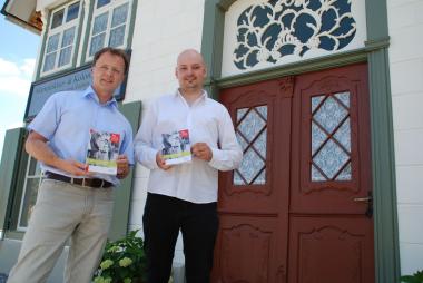Dr. Hubertus Michels (links), Leiter des Referates Bauwesen im LWL-Freilichtmuseum Detmold, und Kai Reinbold, wissenschaftlicher Volontär des Museums, freuen sich über die neue Publikation "Bitte recht freundlich!" zum Haus Schwenger mit Fotoatelier Kuper. <br>Foto: LWL<br />