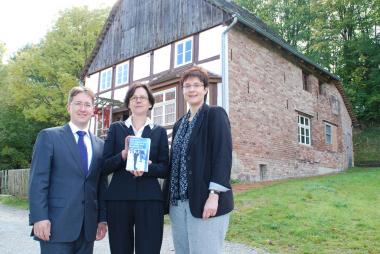 Joachim Hunold, Dr. Brigitte Labs-Ehlert und Gefion Apel (v. l.) vor Haus Uhlmann im Paderborner Dorf, das der gedankliche Anknüpfungspunkt für die Reihe Dorfgeschichten ist. <br>Foto: LWL<br />