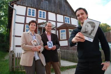 Gefion Apel, Leiterin des Referates Kulturvermittlung im LWL-Freilichtmuseum Detmold, Dr. Markus Köster sowie Jan Telgkamp (beide LWL-Medienzentrum für Westfalen) präsentierten die DVD ¿Brief an eine verlorene Freundin¿. Im Hintergrund ist das Haus Uhlmann im LWL-Freilichtmuseum Detmold zu sehen. <br>Foto: LWL<br />
