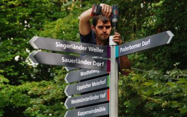 Alexander Stach von der Firma Meng beim Installieren des neuen Wegeleitsystem im LWL-Freilichtmuseum Detmold. <br>Foto: LWL<br />