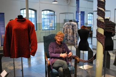 Mitmachen erwünscht: Museumsmitarbeiterin Sigrid Hun-gerkamp fügt dem Gemeinschaftsschal in der Ausstellung ¿Verstrickungen¿ einige Reihen hinzu. <br>Foto: LWL<br /> 