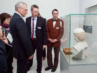 LWL-Direktor Dr. Wolfgang Kirsch (v.l.), LWL-Museumsleiter Dr. Josef Mühlenbrock und LWL-Chefarchäologe Prof. Dr. Michael Rind betrachten gemeinsam mit Journalisten den Kopfschmuck einer römischen Frau aus dem 3. Jahrhundert n.Chr,<br>Foto: LWL/S. Brentführer<br />