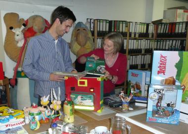Vom Deutschbuch bis zum riesigen Gallier aus Plüsch: Beim Auspacken der frisch eingetroffenen Kisten holen Museumspädagogin Renate Wiechers (r.) und Volontär Stephan Quick (l.) Asterix-Artikel aller Größen und Formen ans Licht. <br>Foto: LWL/E. Strothenke<br />