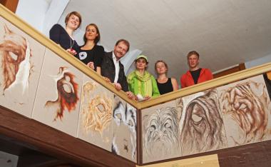 Hanna Verena Kier, Julia Warnecke, LWL-Museumsleiter Dr. Jan Carstensen, Lili Fischer, Anne Boland und Lukas van Hövell (v. l.) an einem der ¿Münsteraner Kunsteinfälle¿, einer Reihe von Fragmenten lebhafter Hundeporträts im Haus Stahl des LWL-Freilichtmuseums Detmold.<br> Foto: LWL/Jähne<br />