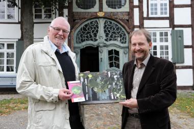 Aus der Perspektive des Fotografen: LWL-Museumsleiter Dr. Jan Carstensen (rechts) überreicht Gewinner Georg Koch vor dem Haus Stahl im ¿Paderborner Dorf¿  den ersten Preis. <br>Foto: LWL/Sanchez<br />