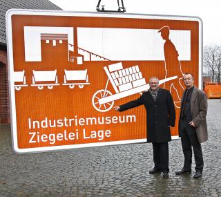 LWL-Direktor Dr. Wolfgang Kirsch (l.) und LWL-Museumsleiter Willi Kulke mit dem neuen Autobahnschild, das auf das LWL-Ziegeleimuseum hinweist. <br>Foto: LWL<br />